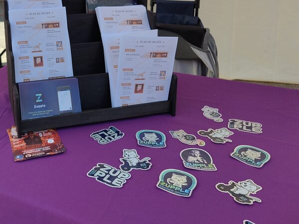 Les livrets « Plan du musée » et des stickers d’Eurêka sur la table du stand.
