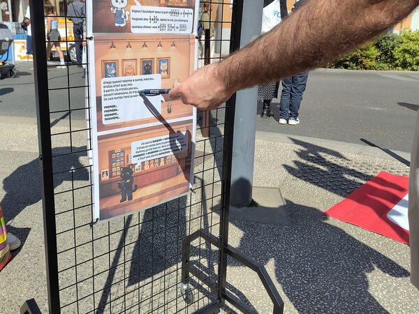 Une main pointe le témoignage d’un employé sur une affiche du musée.